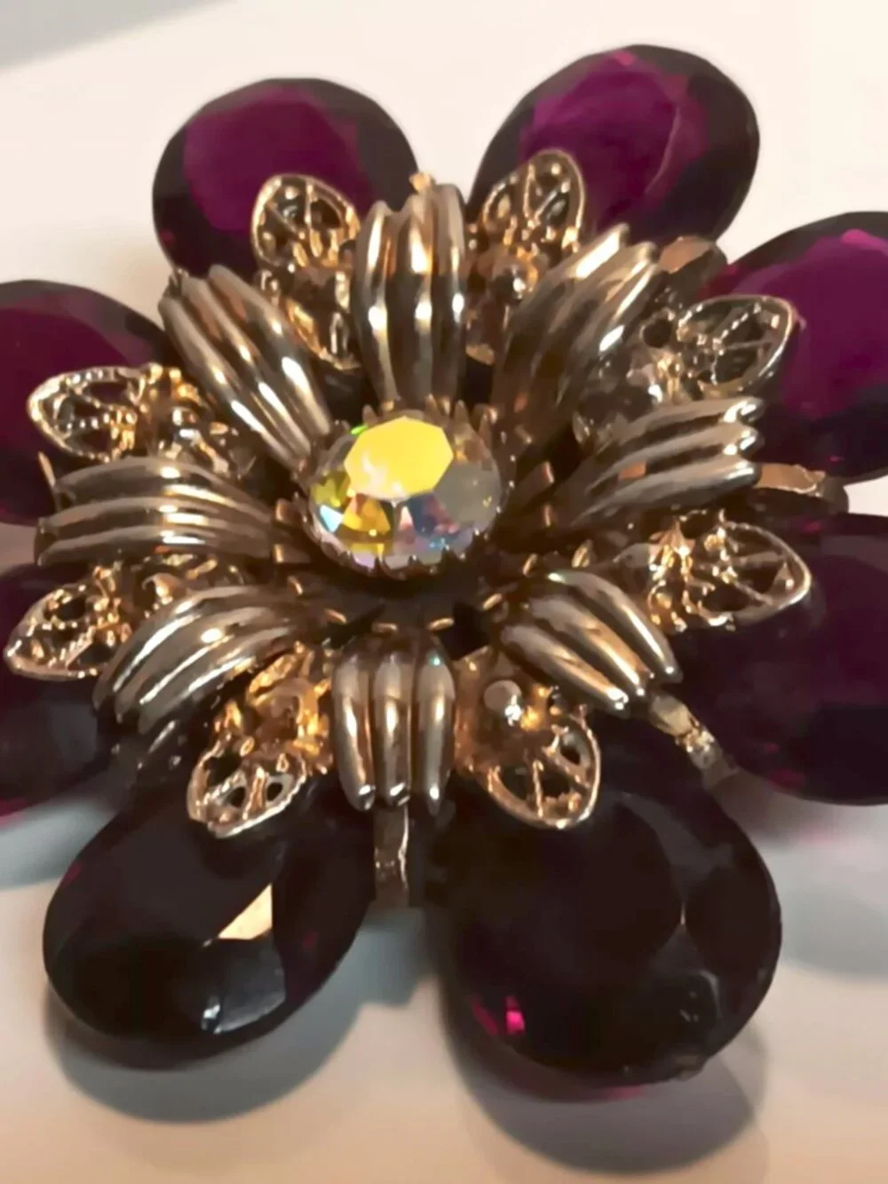 Vintage ruby lucite brooch with aurora borealis central rhinestone.
